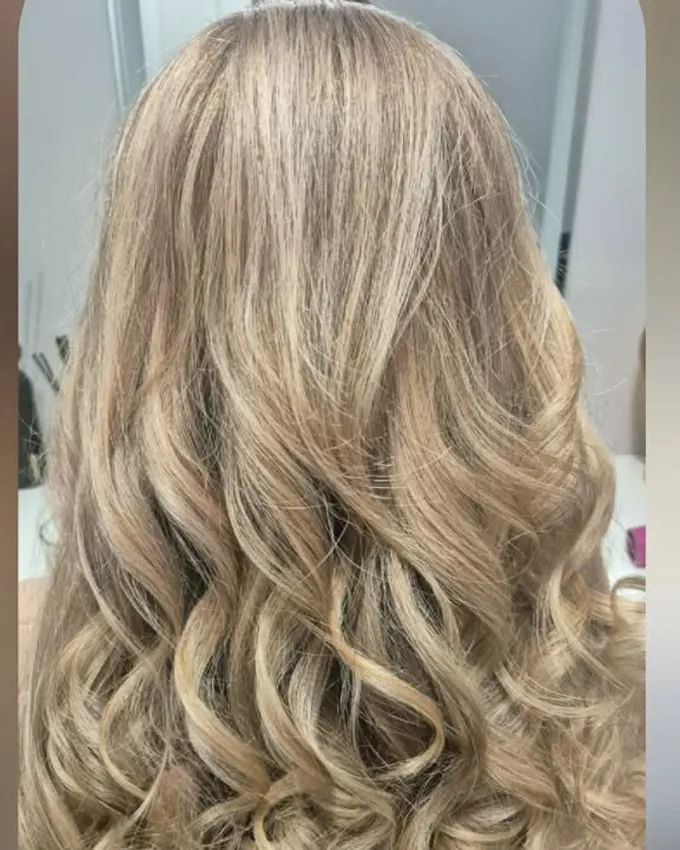 A soft, evenly toned blond styled into waves
